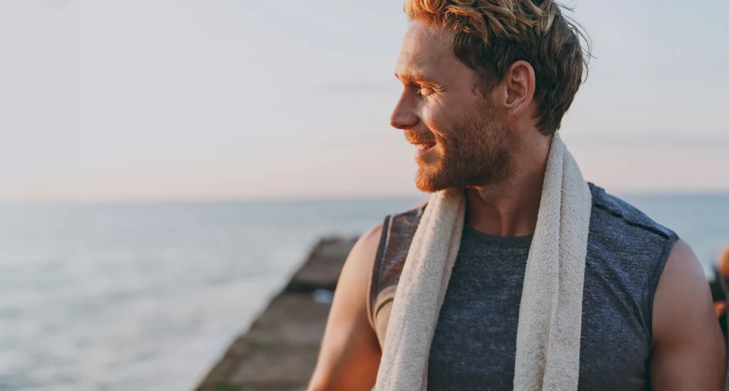 side profile of attractive man after a workout watching the sunset