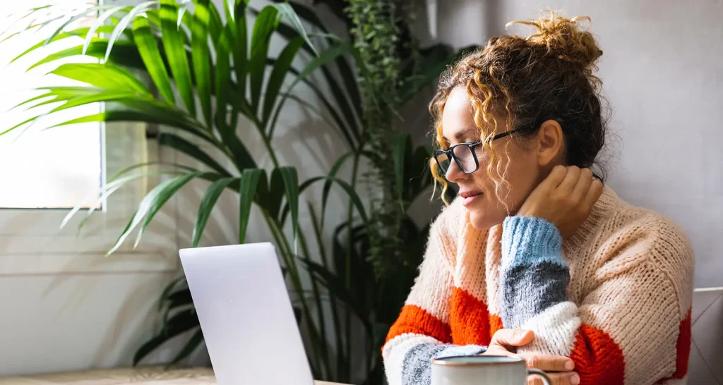 Serene woman looking and reading on laptop