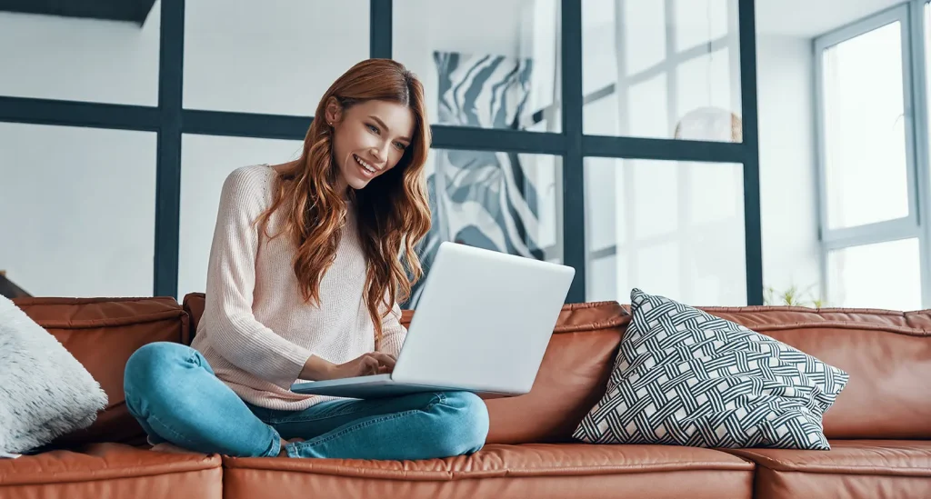 Attractive young woman using laptop and smiling